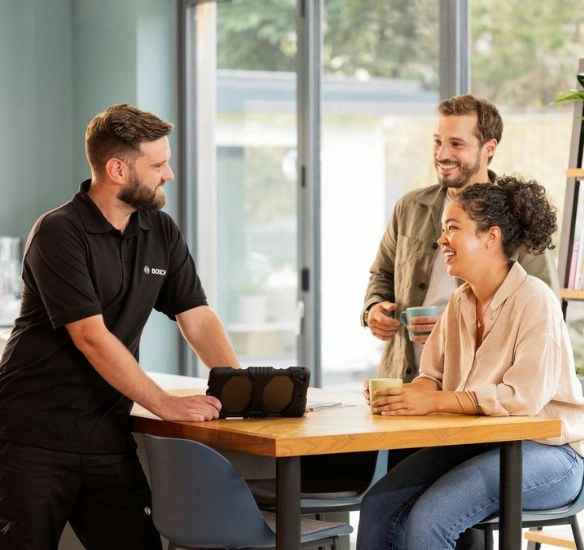 Installer talking to customers over a kitchen counter